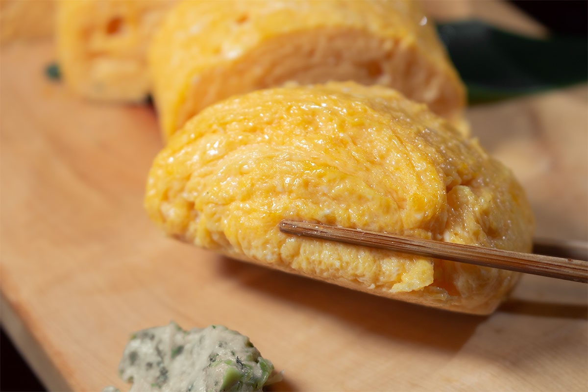 卵道のだしまきを箸で持ち上げる